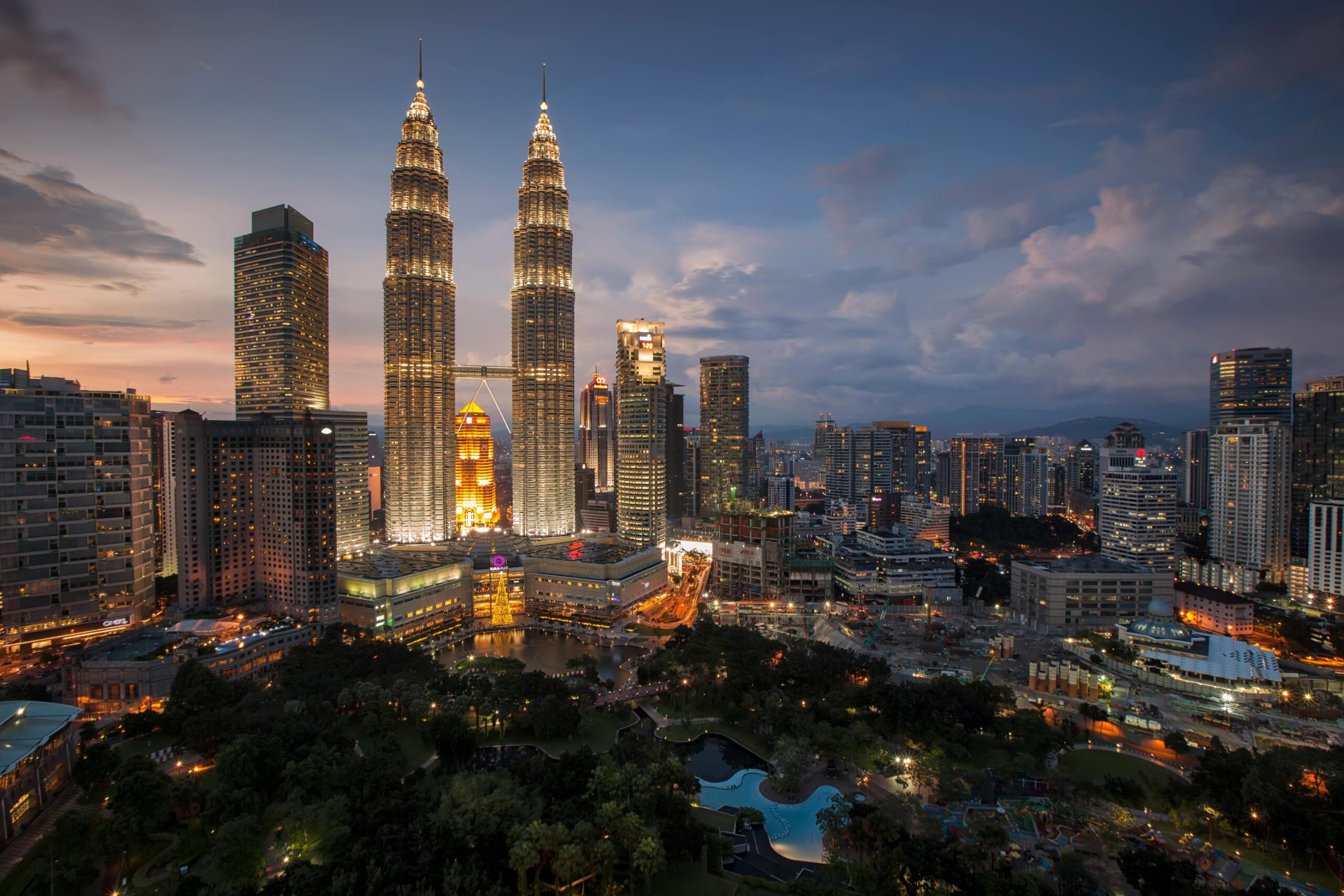 Home Stunning Kuala Lumpur skyline featuring the illuminated Petronas Towers at twilight.