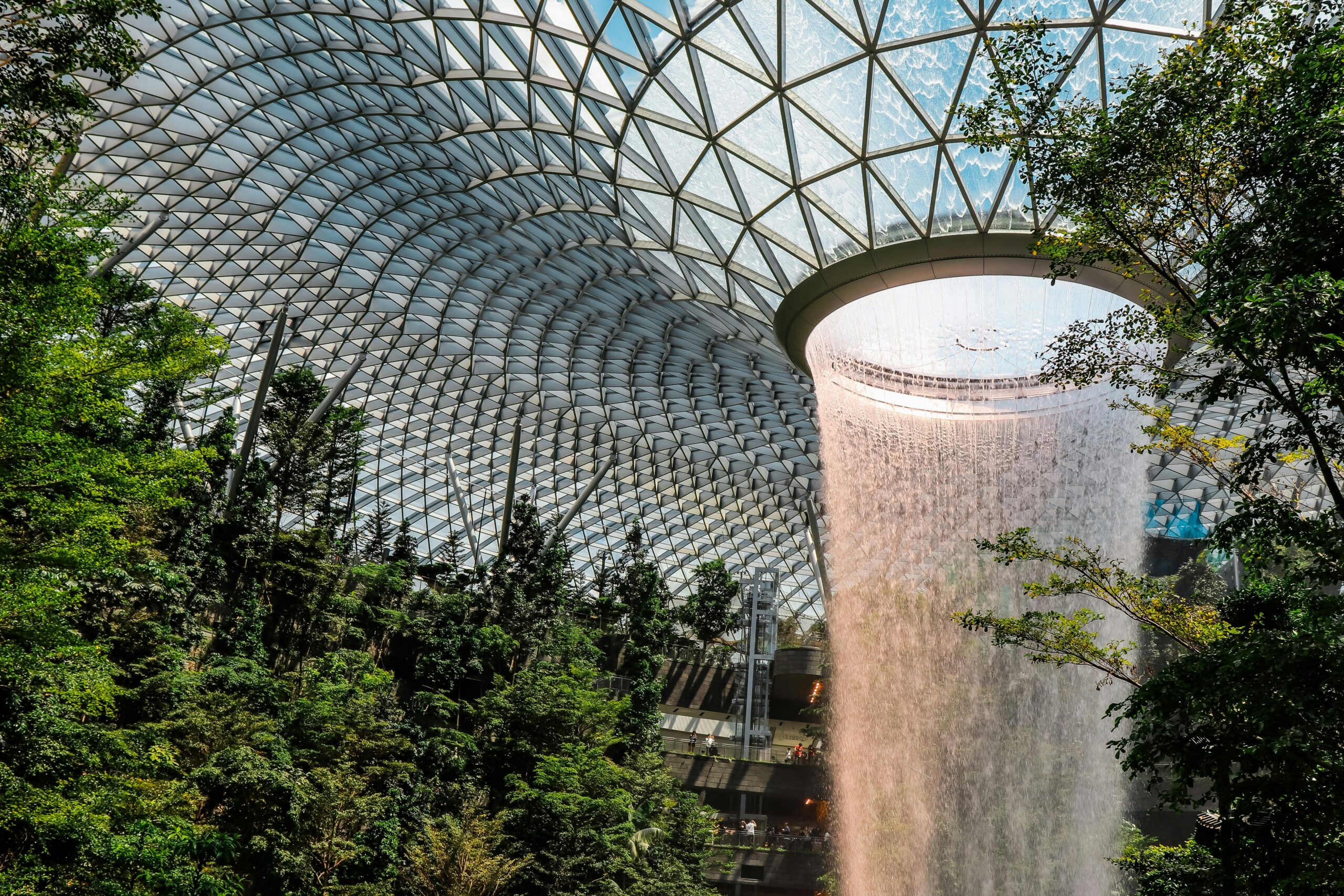 Home The iconic indoor waterfall at Jewel Changi Airport surrounded by lush gardens.