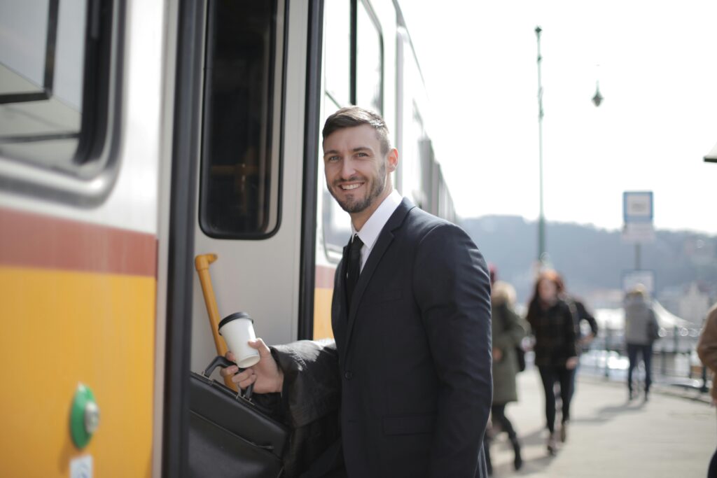 pexels photo 3778609 3778609 Confident businessman with suitcase and coffee boarding train during daily commute.