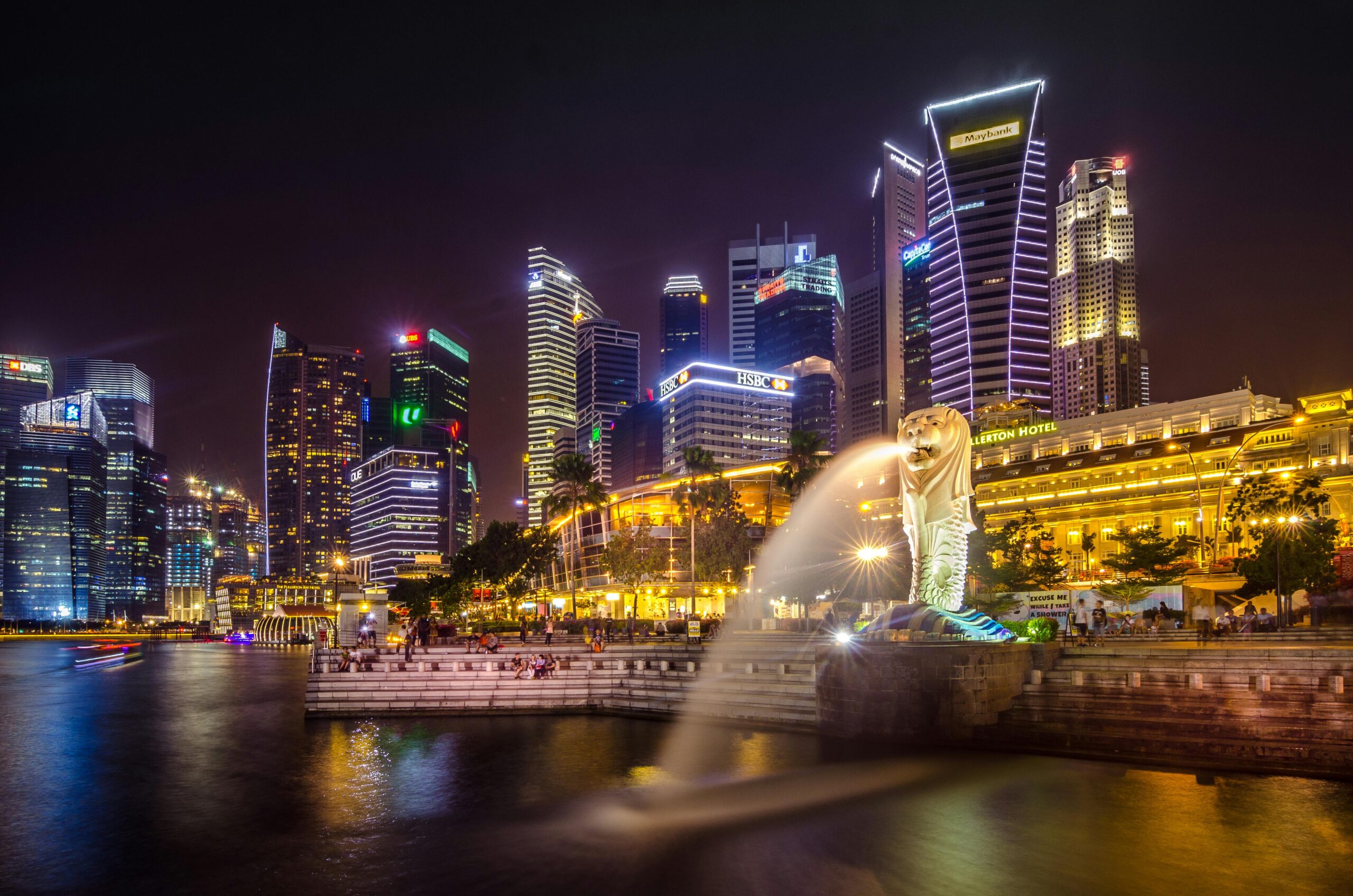 Home Dazzling view of the Singapore cityscape with Merlion and illuminated skyscrapers at night.